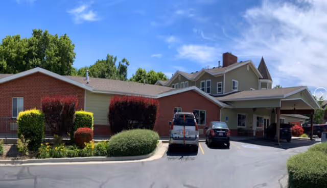 Exterior view of The Lodge at Jordan River with parked cars and landscaping.