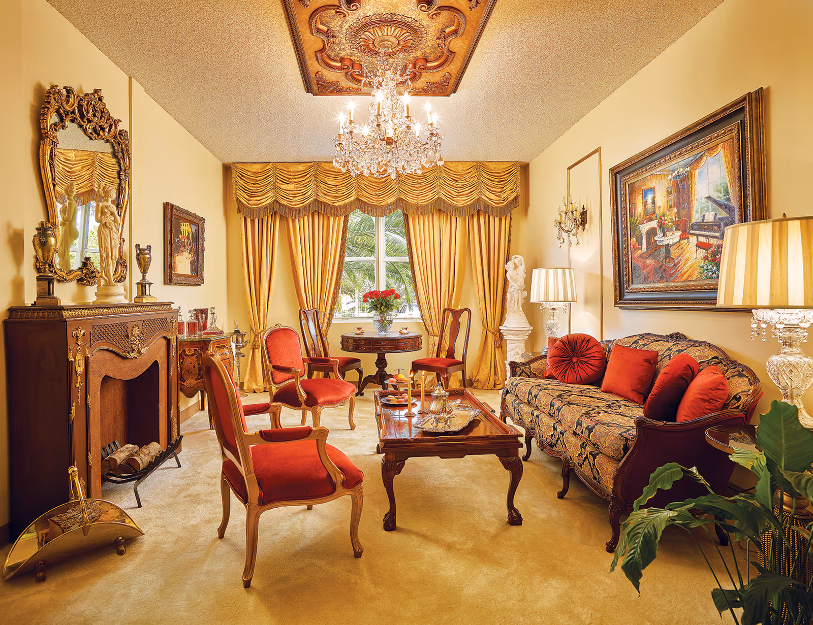 Luxurious living room with ornate furniture, chandelier, and gold drapes.