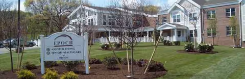 Exterior view of Wingate Residences at Weston with a landscaped lawn and sign