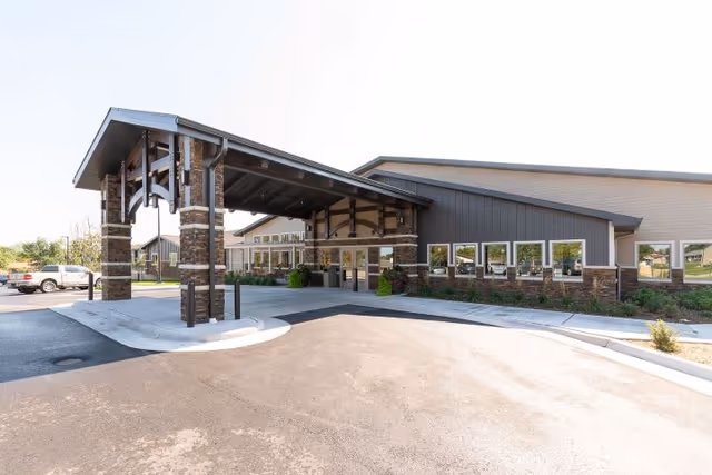 Covered main entrance/porte-cochere of a single-story assisted living building with adjacent parking.