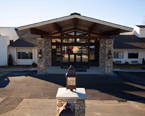 Front entrance of Lincoln Court Assisted & Senior Living with stone pillars.