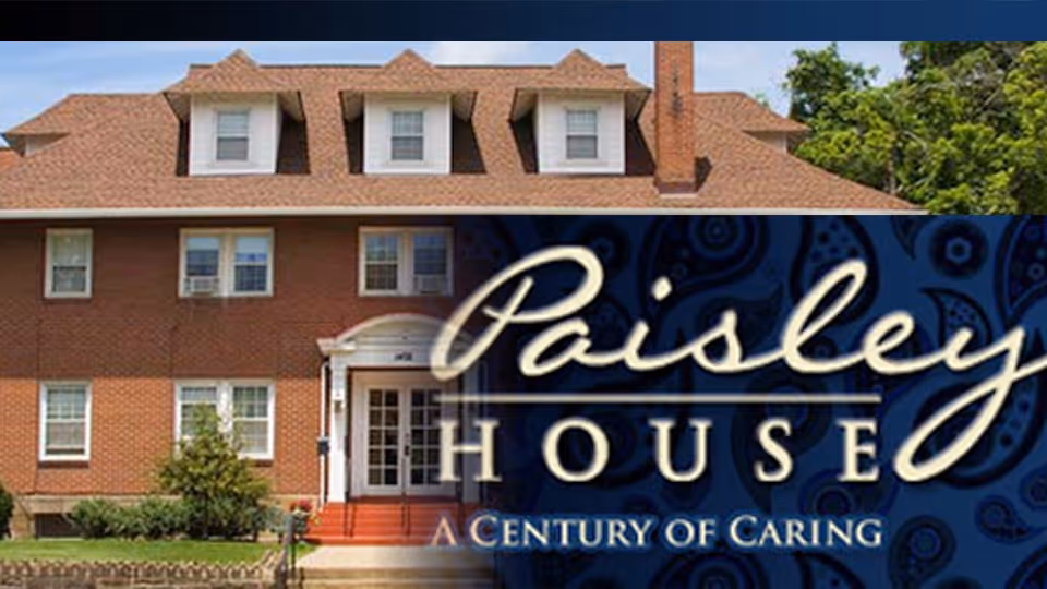 Front exterior of a brick multi-story house with a graphic overlay reading "Paisley House — A Century of Caring".