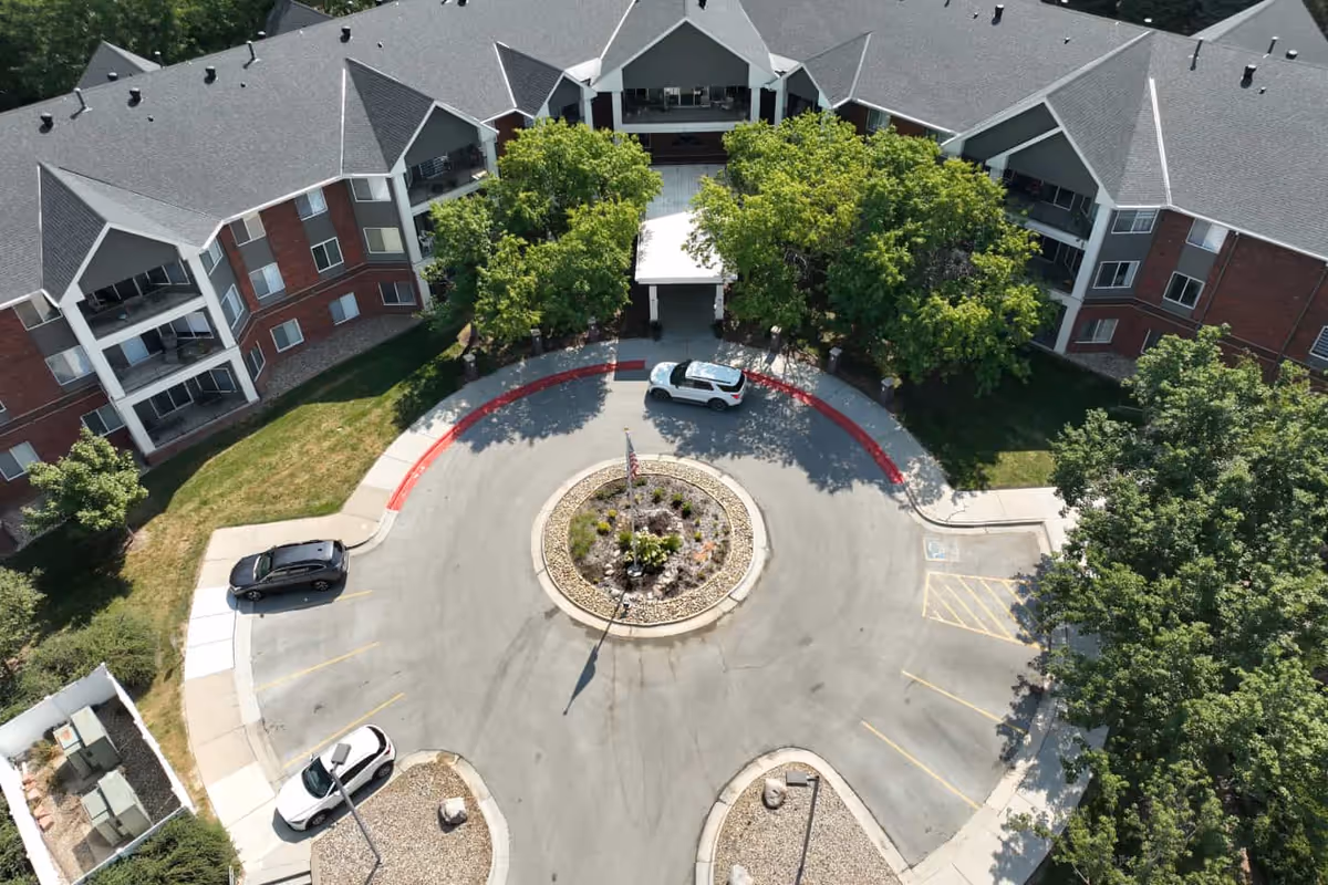 Aerial view of Arboretum Village senior living campus with a circular driveway, entrance, and surrounding trees.