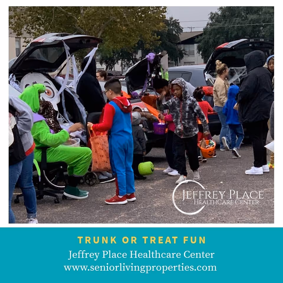 Children in Halloween costumes gather around decorated car trunks to trick-or-treat outside Jeffrey Place Healthcare Center.