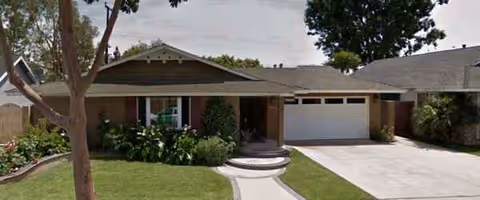 Single-story suburban-style facility facade with front lawn, walkway, and attached garage.