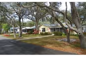 Exterior view of Maranatha Manor senior living facility with a front entrance and trees.