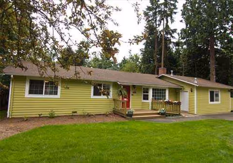 Yellow single-story building with a small front porch and green lawn.