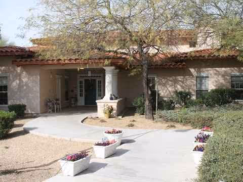 Front entrance of Barton House with curved walkway, planters, and trees.