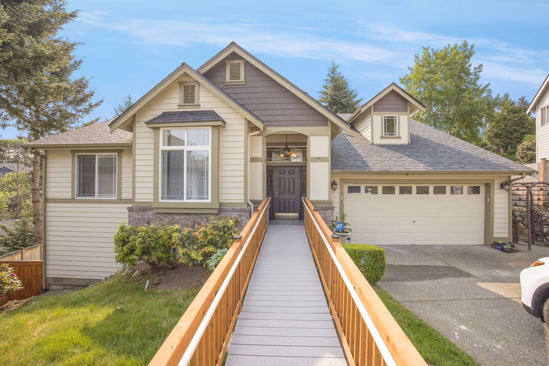 Front view of a beige residential home with a central wheelchair ramp.
