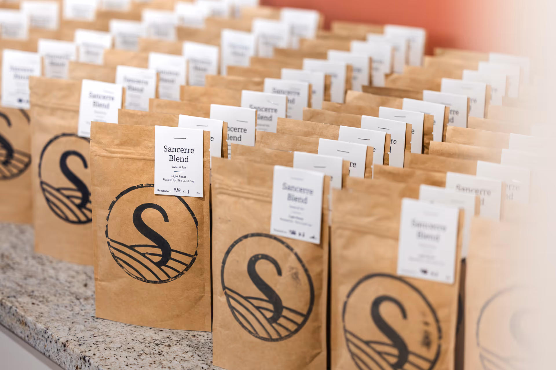 Rows of brown paper bags labeled "Sancerre Blend" arranged on a countertop.