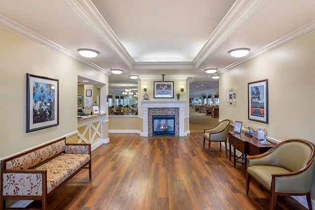 Lobby-style common area with a central fireplace, hardwood floors, and seating along both walls.