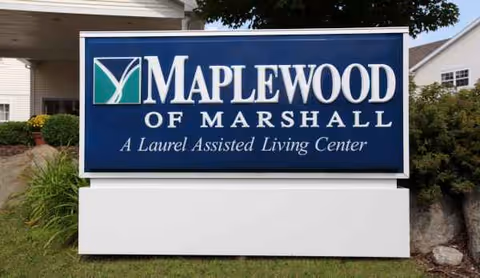 Outdoor blue sign reads MAPLEWOOD OF MARSHALL for an assisted living center.