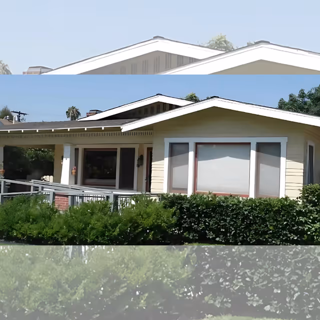 Single-story cream-colored house with a covered porch, accessibility ramp, and trimmed hedges in front.