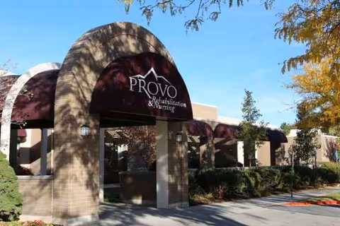 Exterior view of Provo Rehabilitation & Nursing entrance with maroon awnings and landscaping.