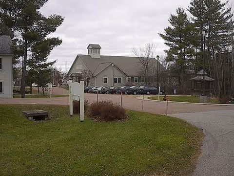 Exterior view of Whitney Hill Homestead with a front-facing building and parked cars