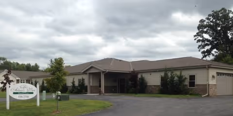 Exterior view of Arbor View senior living facility with entrance, sign, and landscaped surroundings.