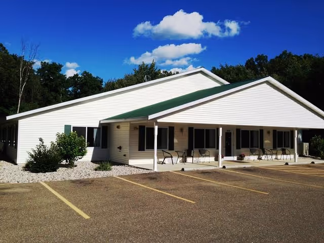 Single-story Care Partners Assisted Living Stevens Point facility with a covered front porch and parking lot.