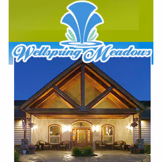 Front entrance of Wellspring Meadows assisted living with a lit porch and large logo banner above.