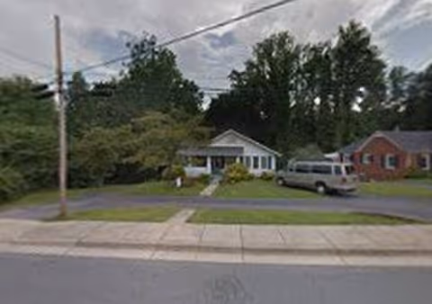 Front view of Wintergreen Assisted Living, a single-story facility with a van parked beside the driveway.
