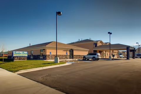Exterior view of Thatcher Brook Rehabilitation and Care Center with parking lot and driveway.