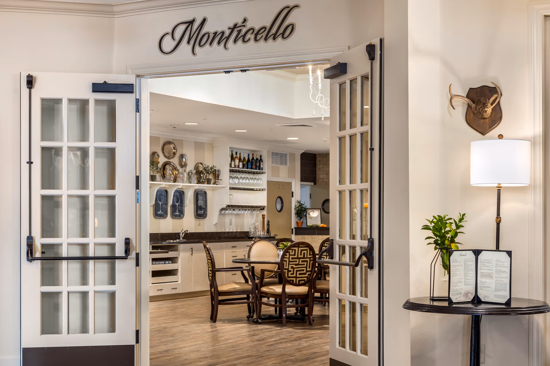 Open double doors labeled 'Monticello' reveal a dining room with a round table and chairs and a small bar/kitchen area.