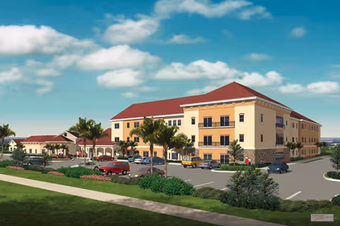 Exterior view of a three-story senior living building with a red roof, parking lot, palm trees, and cars under a blue sky.