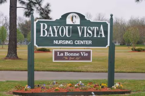 Bayou Vista Nursing Center sign on a lawn with flowers.