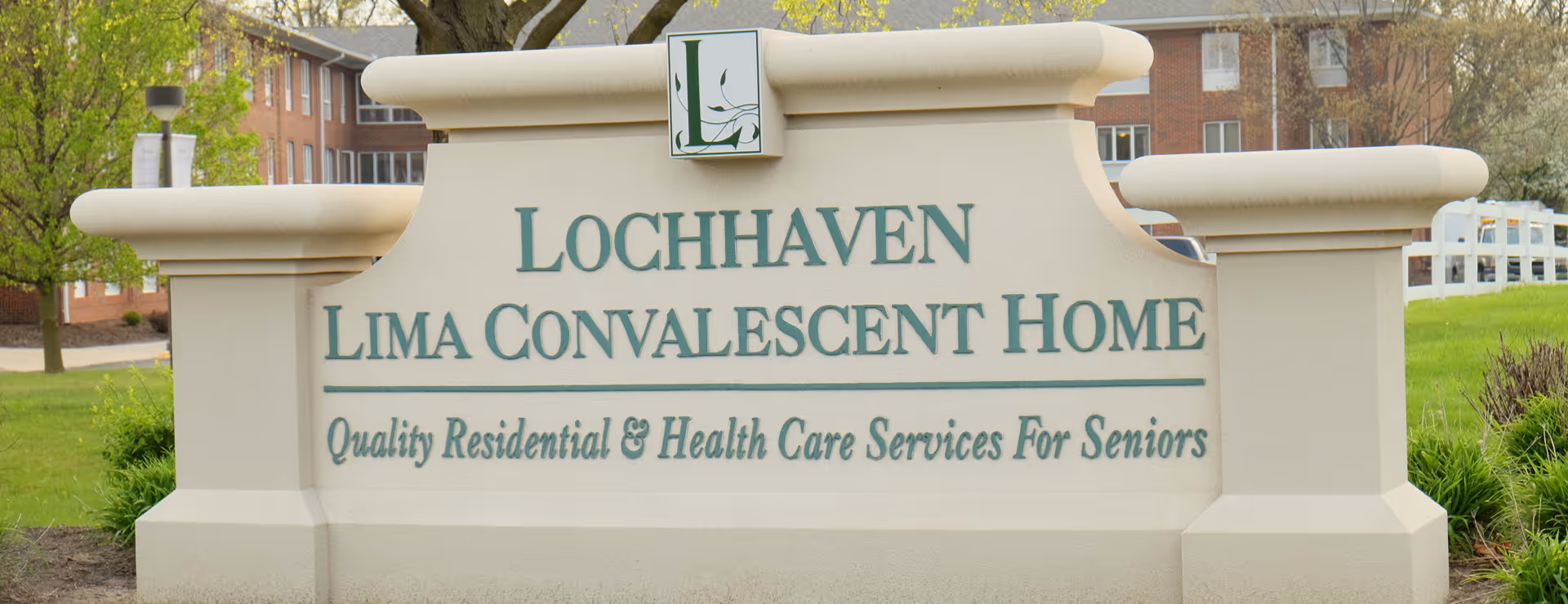 Stone entrance sign reading "Lochhaven Lima Convalescent Home — Quality Residential & Health Care Services For Seniors" in front of a brick building and lawn.