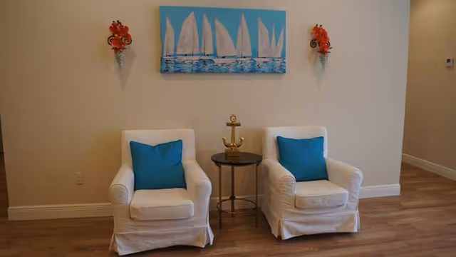 Castlewood ALF lounge with two white armchairs, blue cushions, and a small table.