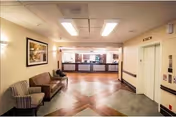 Interior lobby with seating area and a reception desk at the far end.