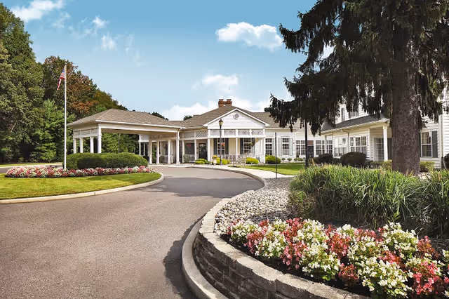 The Residence at Voorhees exterior shows a curved driveway, landscaped beds, and a welcoming entrance.