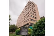 Multi-story brick apartment building labeled Mary Agnes Manor with a front lawn and entrance sign.