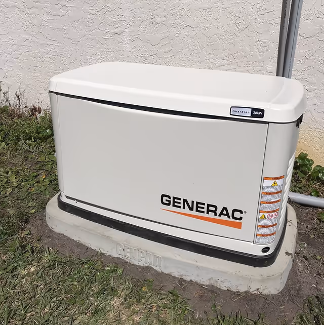 A white Generac standby generator mounted on a concrete pad outside next to a stucco wall.
