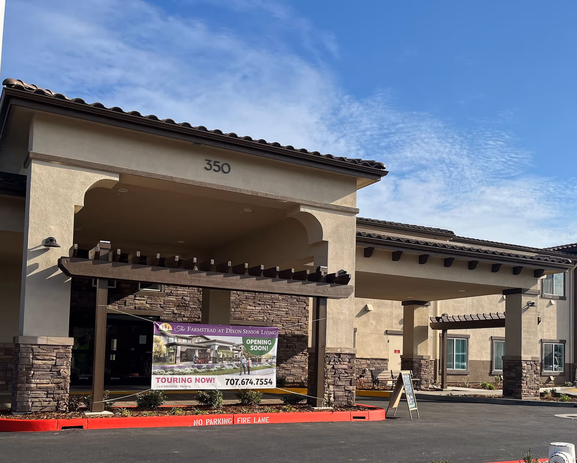 Exterior view of The Farmstead at Dixon Senior Living entrance with banner