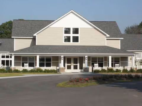 Front exterior of Medilodge of Montrose, a senior living facility with a porch and rocking chairs.