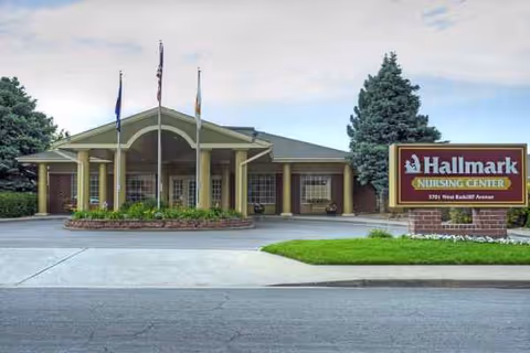 Exterior view of Hallmark Nursing Center with pillars, flags, and a large sign.