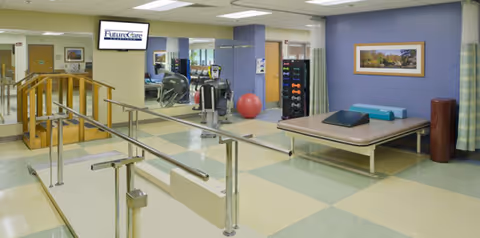 Therapy gym with parallel bars and exercise equipment in a Courtland facility.