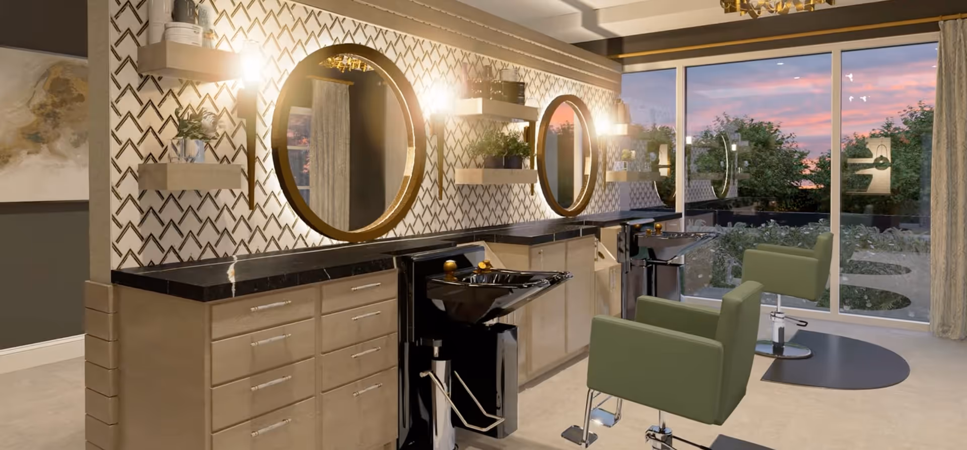 Interior of a modern salon area with two green salon chairs facing black wash basins. The wall behind features two large round mirrors with backlighting, floating shelves with plants and decor, and a patterned wallpaper. Large windows show a view of greenery and a colorful sunset sky outside.