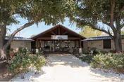 Front view of Lake Village Nursing and Rehabilitation Center entrance with trees and landscaping.