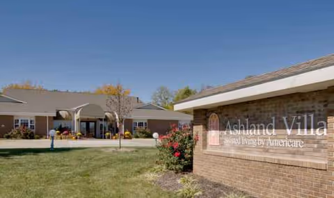 Exterior view of Ashland Villa senior living facility with a brick entrance sign.