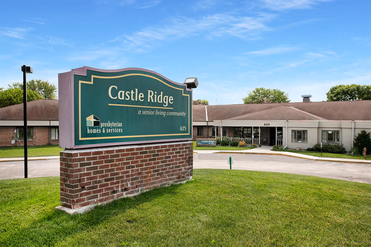 Sign for Castle Ridge senior living community in front of the facility.