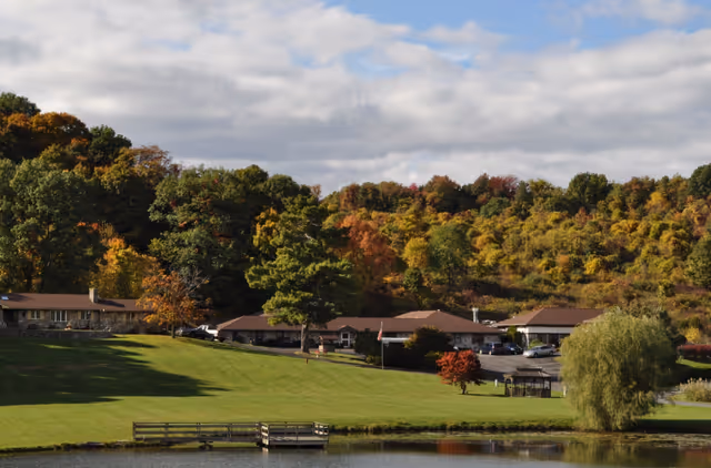 Autumn exterior view of Valley Vista Assisted Living campus beside a lake.