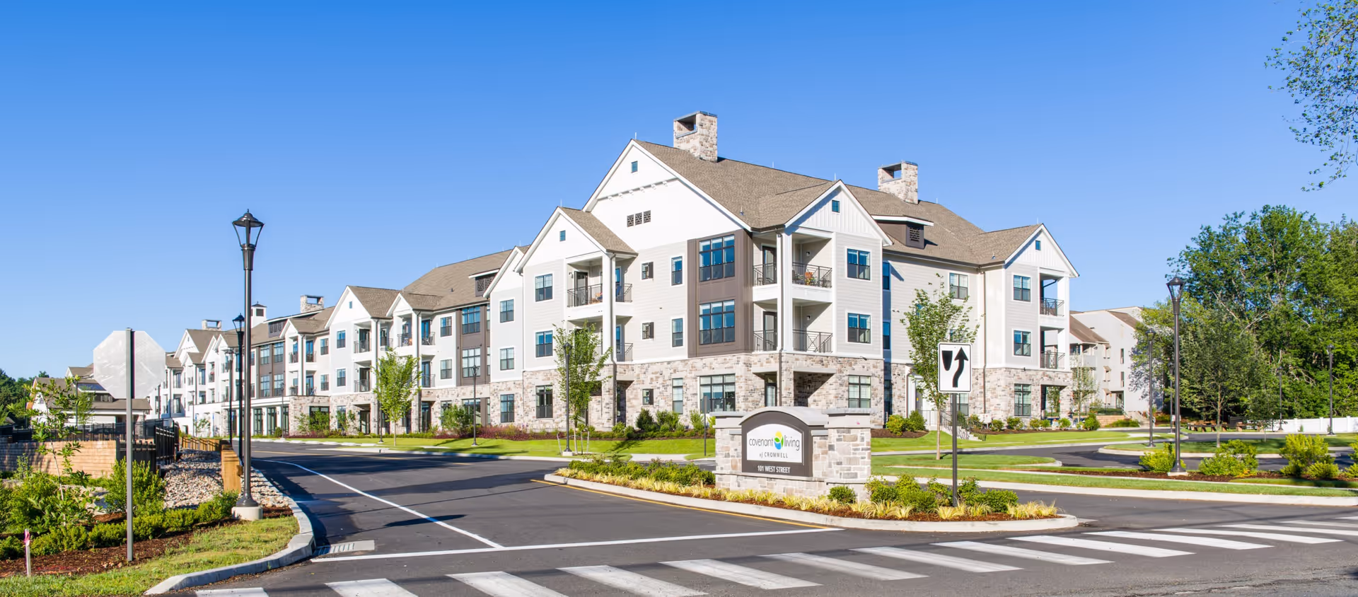 Exterior view of a modern senior living building with stone accents and landscaped grounds.
