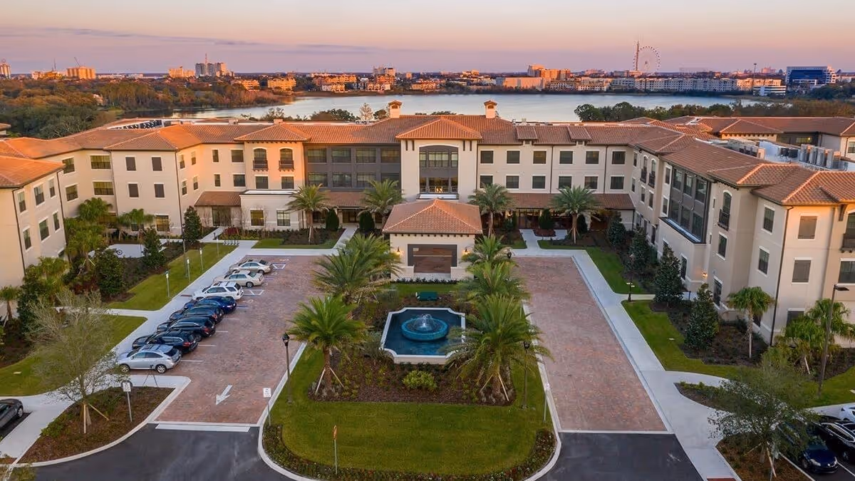 Aerial view of HarborChase of Dr. Phillips exterior showing U-shaped building, courtyard, fountain, and palm trees.