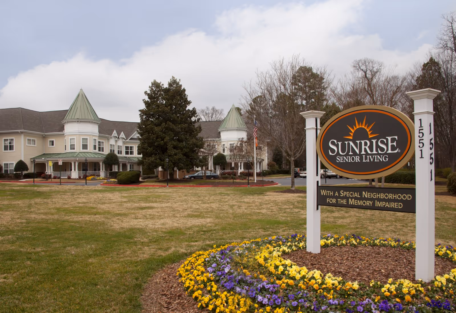 Sunrise Senior Living exterior with sign, manicured lawn, and a large front-facing building.