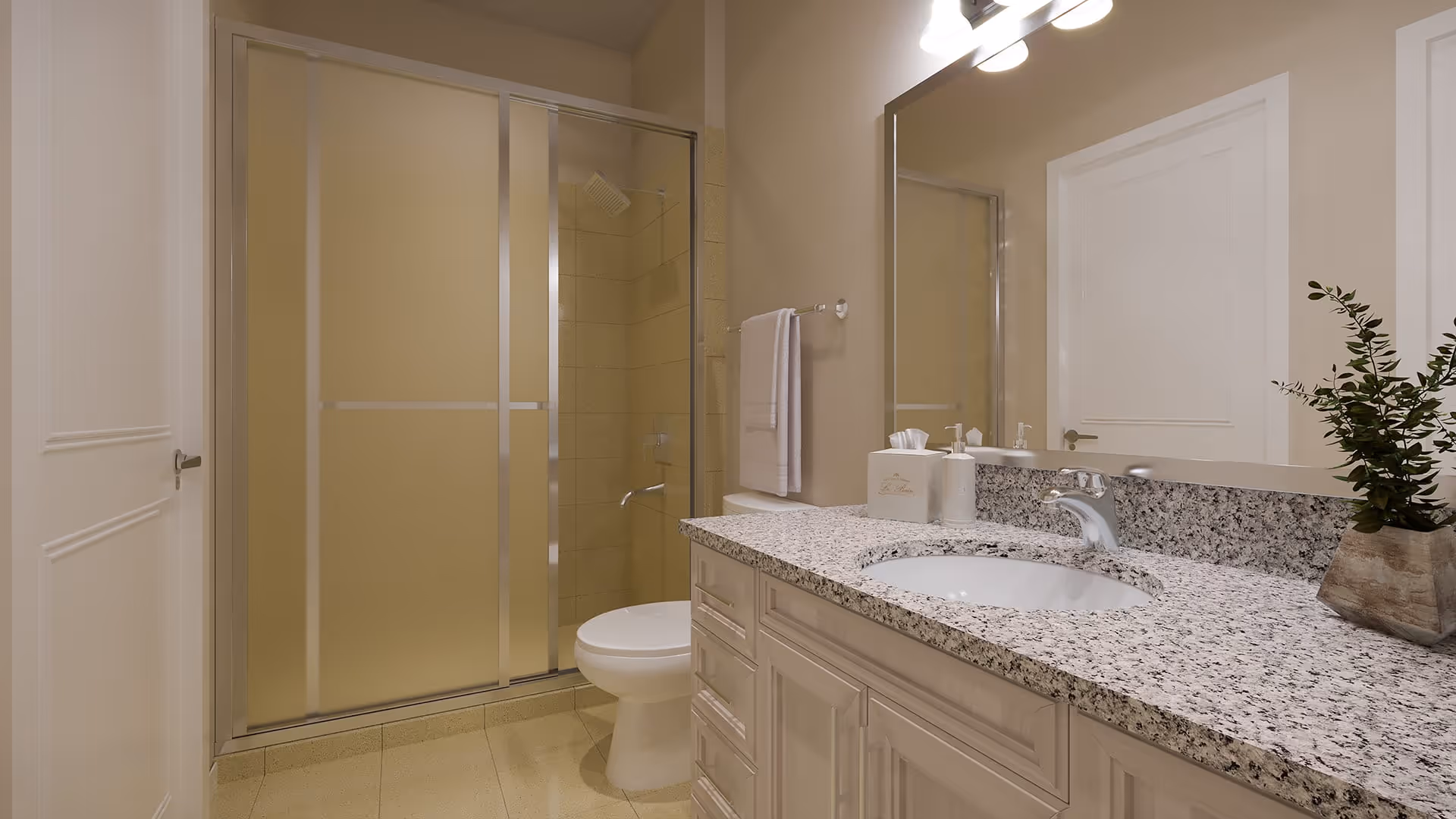 Well-lit bathroom with a granite countertop vanity and sink, mirror, toilet, and a sliding-door shower.