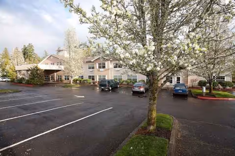Exterior view of Princeton Village by Cogir with blooming trees and a parking lot