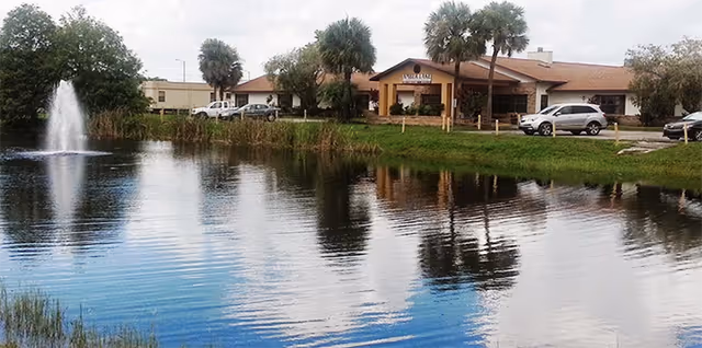 Exterior view of Buenaventura Assisted Living Facility with pond and fountain.