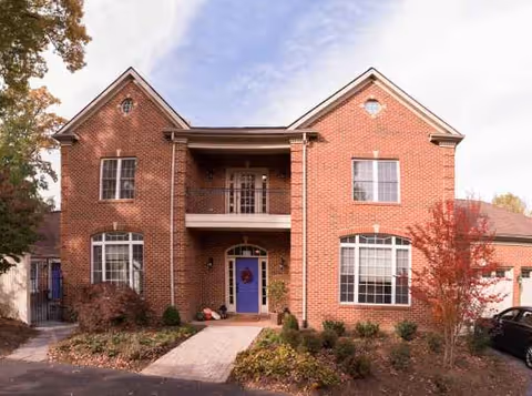 Brick two-story assisted-living facility with a central entry and symmetrical windows.