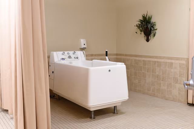 A large white walk-in bathing tub in a tiled room with beige walls and a privacy curtain.